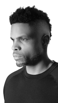 a black and white photo of a man with afro hair