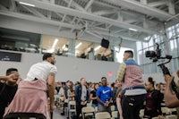 a group of people standing in a room with a camera